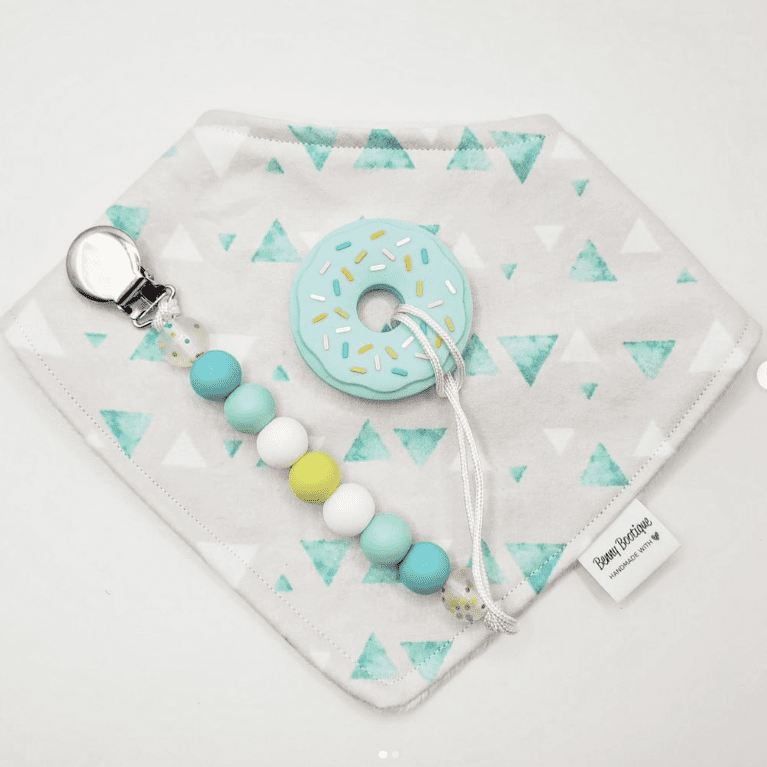 Coordinating pacifier clips, teething beads, and bib from Benny's Bootique.