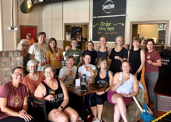 A group photo of a yoga event hosted by Roots and River yoga studio at Smoketown Brewing in Brunswick, MD.