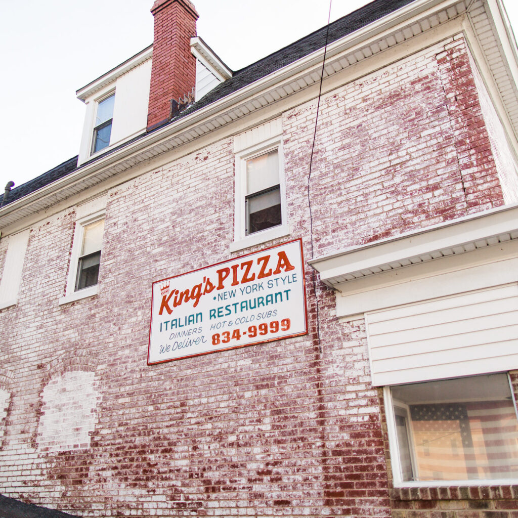 King's Pizza sign on the side of a a brick building